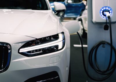 Close-up of a white electric car being charged at an electric vehicle charging station.